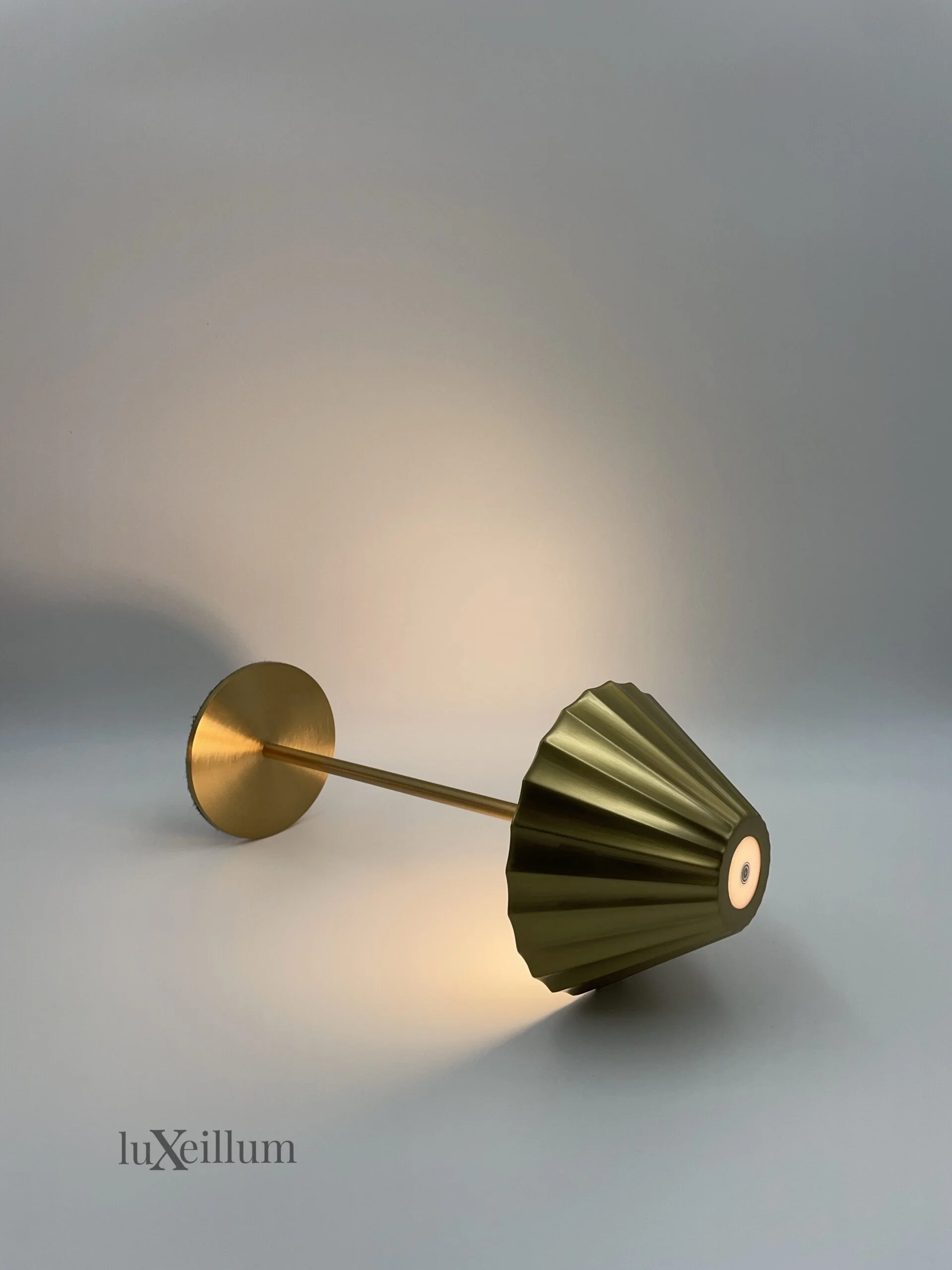 Gold-finish lamp with pleated shade providing warm glow